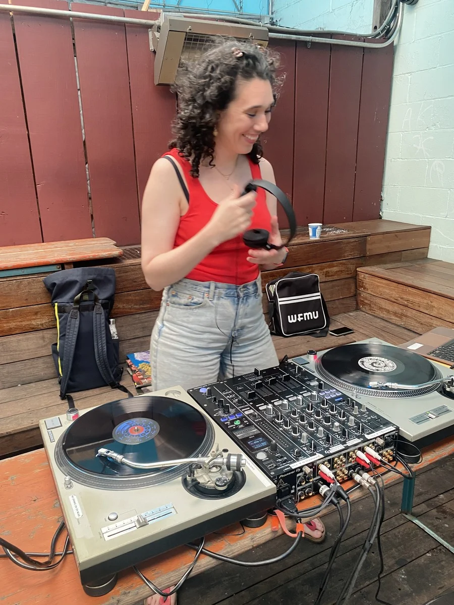 Olivia Bradley-Skill DJing a lively party, with vinyl and real turntables.