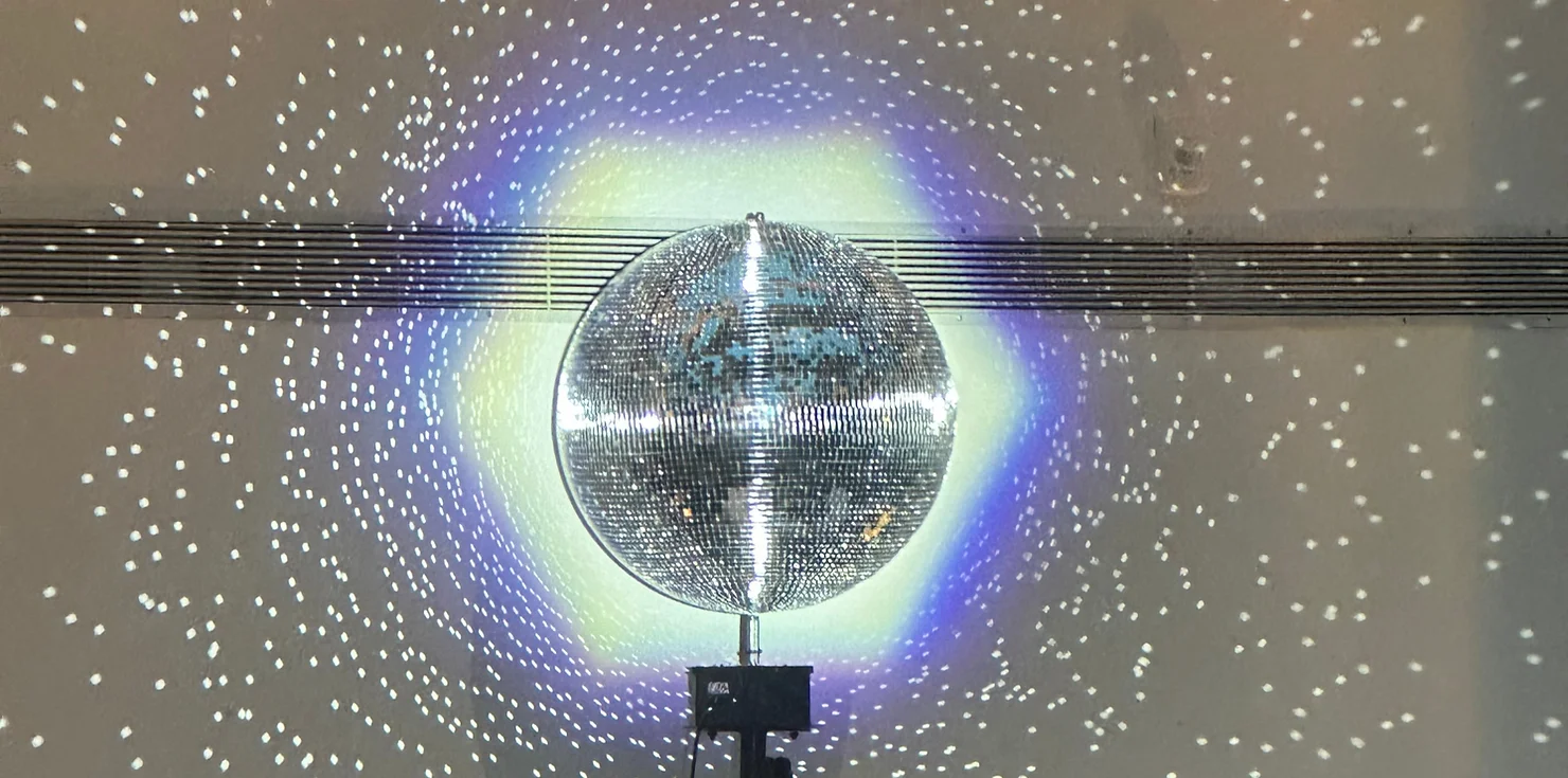 NYC Wedding DJ lighting services featuring a large disco ball creating a starry light effect at a reception venue.