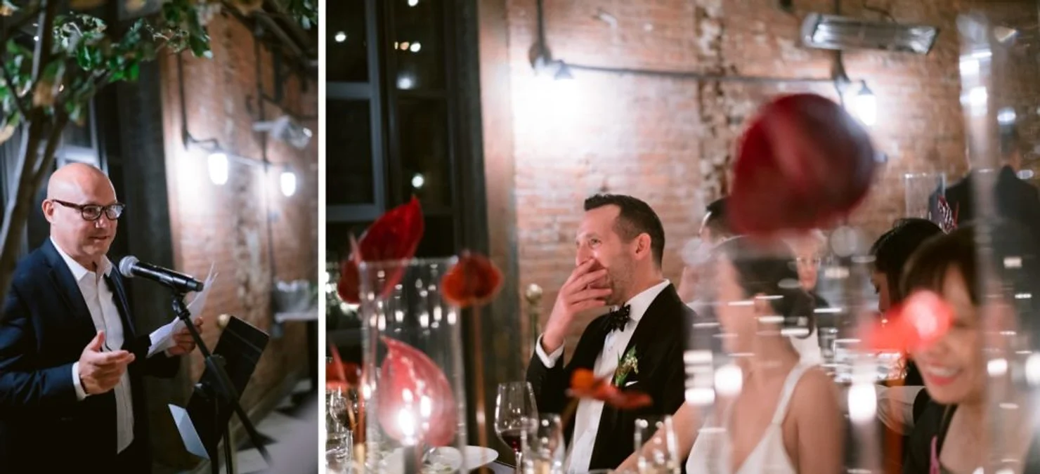 nyc 74 wythe wedding dj  Bald man gives a speech at a formal dinner while guests in tuxedo and dress smile at tables with red flowers and wine glasses
